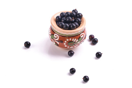 black currant berries in clay pot isolated on white top view, leafの写真素材