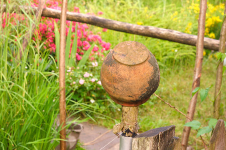 ceramic pot on the fence in the country, grass and flowersの写真素材