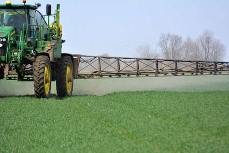 Chortkiv - Ternopil - Ukraine - April 22, 2021. Treatment of wheat crops with insecticides for protection against pests in the farm "Yagelniski".のeditorial素材