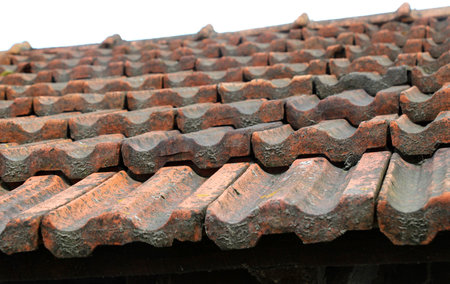 On the roof of the house is an old red ceramic tile