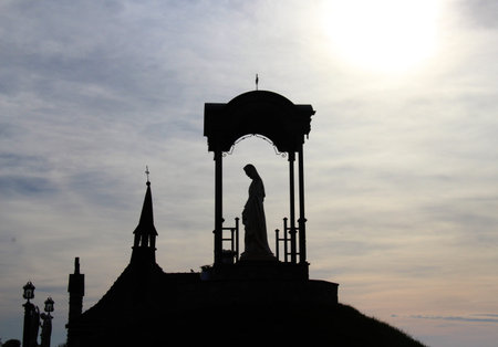 Against a sky background, a graphic figure of a statue of the Virgin Mary under a domeの写真素材