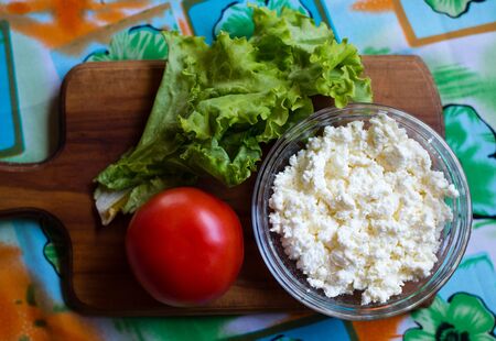 lettuce , cheese, tomato on wooden boardの写真素材