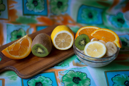 oatmeal, orange, banana, kiwi on wooden boardの写真素材