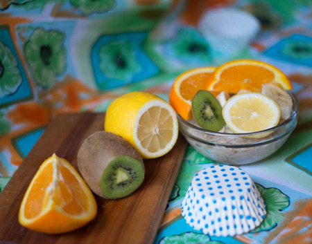 oatmeal, orange, banana, kiwi on wooden boardの写真素材