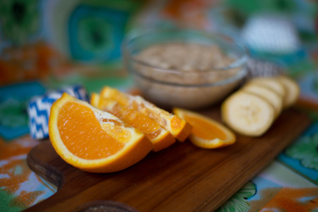 oatmeal, orange, banana, kiwi on wooden boardの写真素材