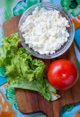 lettuce , cheese, tomato on wooden boardの写真素材