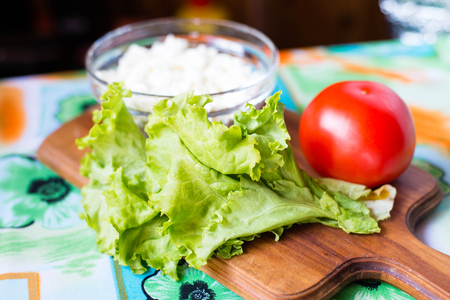 lettuce , cheese, tomato on wooden boardの写真素材