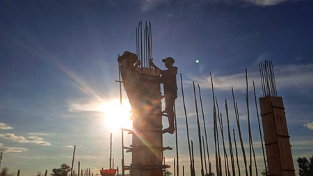 Silhouettes of workers on a construction site, during the hot sun during the day