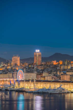 old port of Genoa with Ferris wheel, with boats and reflections on the sea