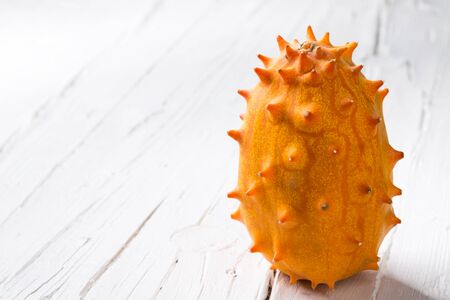 Single kiwano vegetable on white wooden background, closeup.の写真素材
