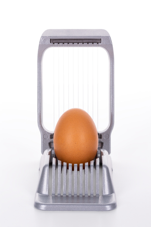 Egg cutter - slicer with brown egg on white background, clipping path, including all background elements, is includedの写真素材
