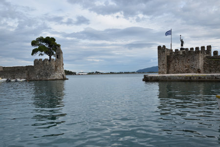 View of the main monuments of Greece. Lepanto, site of the battle where Miguel de Cervantes Saavedra, the author of Don Quixote, participated. Fishing village, Ionian Sea. Greek flagのeditorial素材