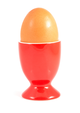 boiled egg in red stand isolated on whiteの写真素材