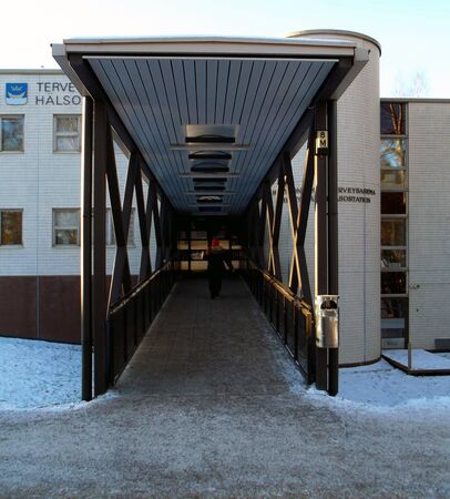A woman walking towards the entrance of the local Health Center.のeditorial素材