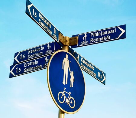 Pedestrian and bicycle sign telling directions and distances to few places.の写真素材