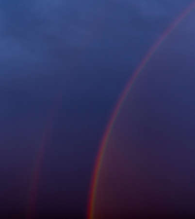 A rainbow in a dark rainy evening.の写真素材