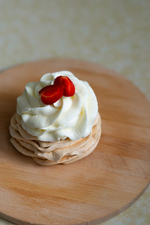 Pavlova cake based on french meringue. Delicious meringue dessert with butter cream and fresh berries (strawberries, blueberries)の写真素材