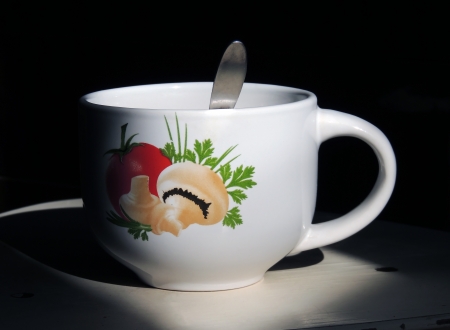 Cup with a picture on a background of darknessの写真素材