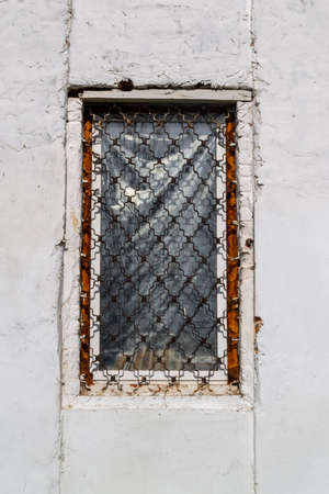 antique window with bars in the process of renovationの写真素材