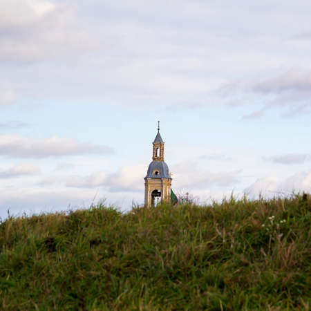 Church spire in the distance. Grass. The sky is overcast.の写真素材