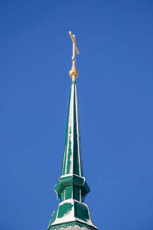 the sharp spire of the Orthodox bell tower against the skyの写真素材