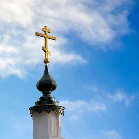 the spire of the Orthodox chapel with a cross on the sky backgroundの写真素材