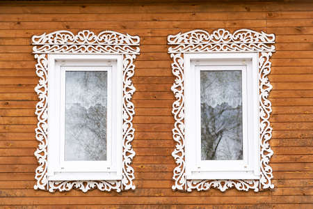 window with carved architraves in a wooden houseの写真素材