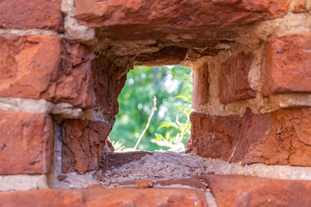 a small window loophole in the brick wall of the old fortress
