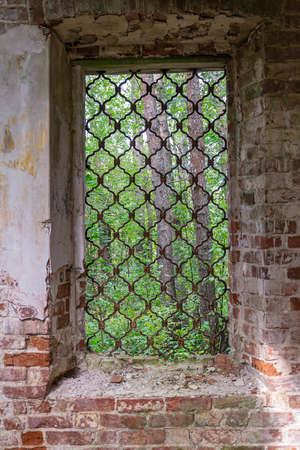 an ancient window of a ruined temple with a metal latticeの写真素材