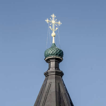 black domes of an Orthodox church with gilded crosses against a blue sky