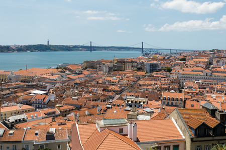 Range or red tile roofs of houses in Lisbon and the river.の写真素材