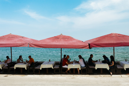Porec, Croatia - July, 2016 - Cafe with sun umbrellas on the Adriatic coast in Porec, Croatia.