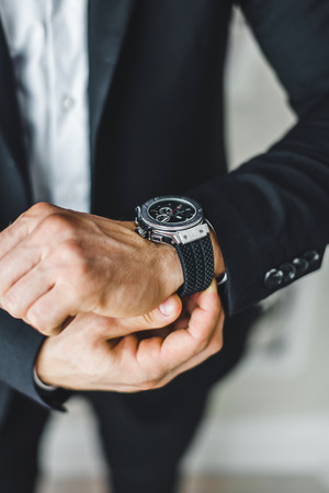 businessman looking at his watch on his hand, watching the timeの写真素材