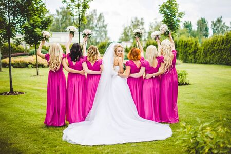 Bride with bridesmaids in a park on the wedding dayの写真素材