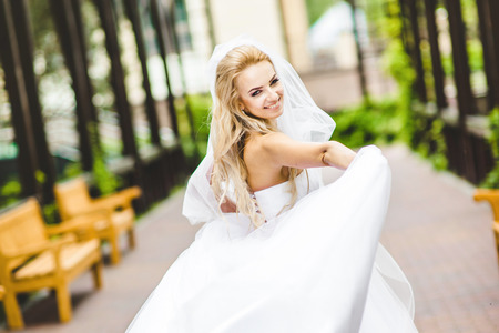 Elegant bride dancing an posing outdoors on a wedding dayの写真素材