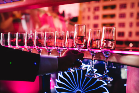 Champagne and glasses on the back seat of a limousine closeup