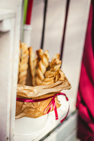 Tasty breadsticks in paper basket. Food on wooden backgroundの写真素材