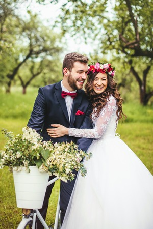 Beautiful bride & groom posing near vintage provence bicycle outdoorの写真素材