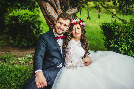 Happy couple, bride & groom hugging near old treeの写真素材