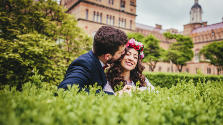 Happy couple, bride & groom hugging in park near old Chernivtsi Universityの写真素材