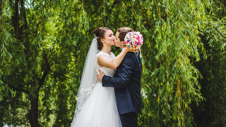 Elegant bride and groom posing together outdoors on a wedding day