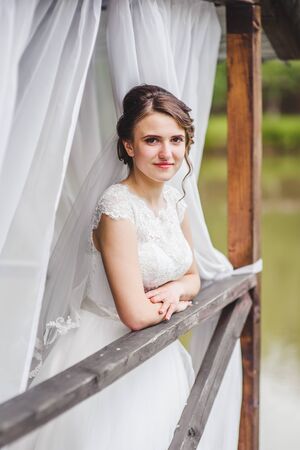 Beautiful bride posing on the pier at the lakeの写真素材