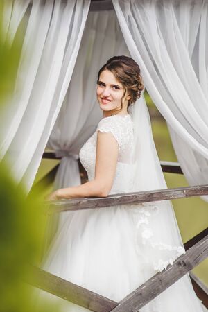 Beautiful bride posing on the pier at the lakeの写真素材