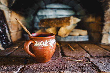 A clay pot with traditional oven for cooking and baking on the backgroundの写真素材