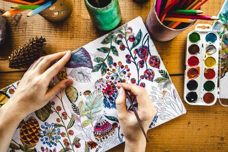 Girls hands with brush painting with watercolor paintsの写真素材