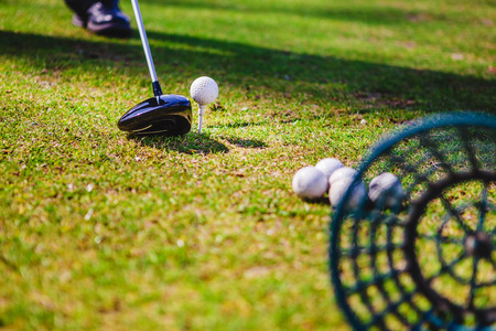 Golf club and ball in green grassの写真素材