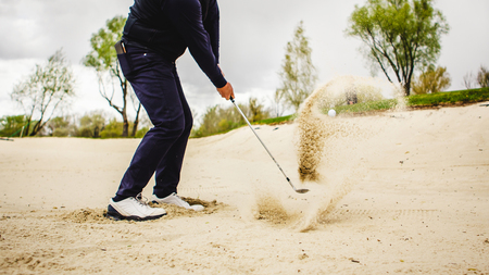 golfplayer hits a ball in the sandの写真素材