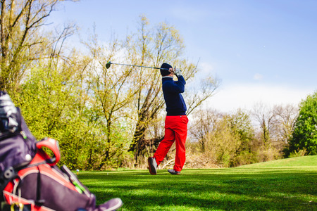 golfplayer hits a ball on the grassの写真素材