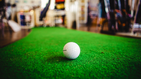 Golf club and ball in green grassの写真素材