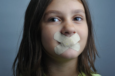 Portrait of a girl with bandaids over her lips 